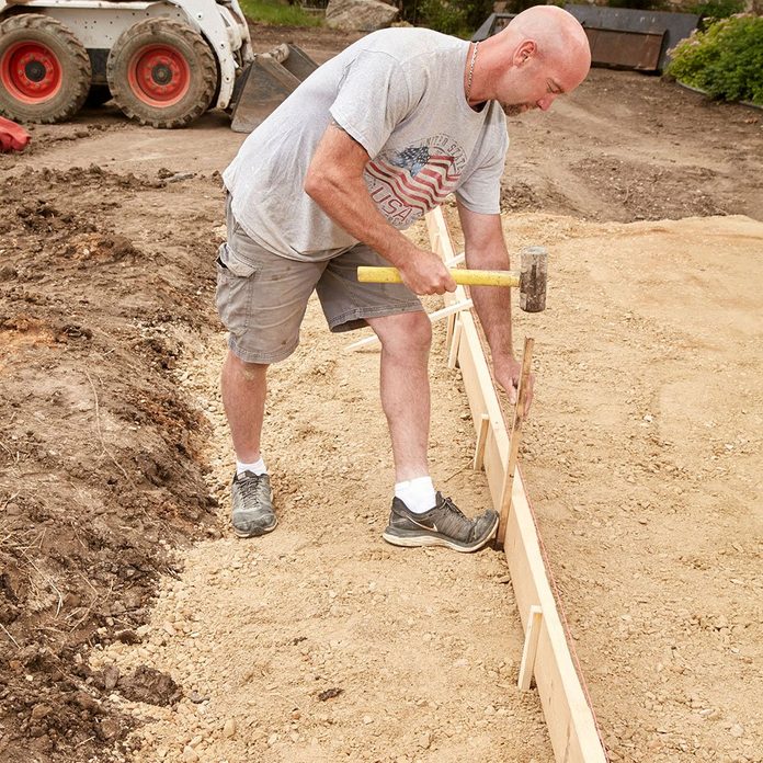 Pounding form stakes into the ground | Construction Pro Tips