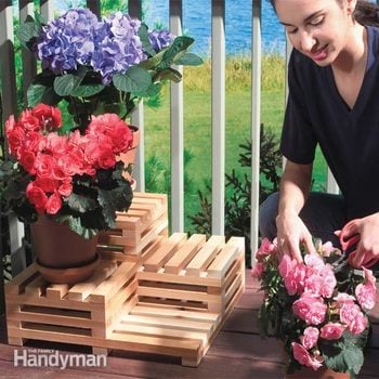 woman places flowers on a tiered plant stand