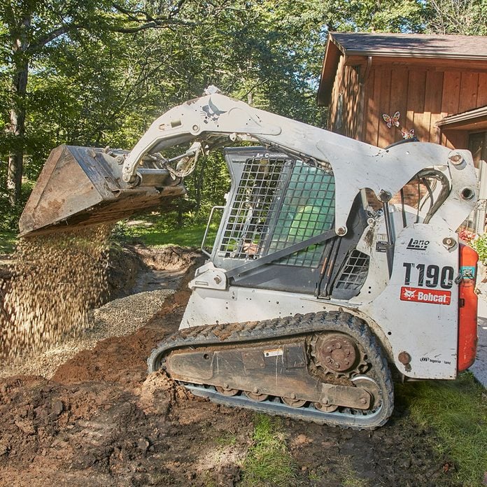 Laying a rock base with a Bobcat | Construction Pro Tips