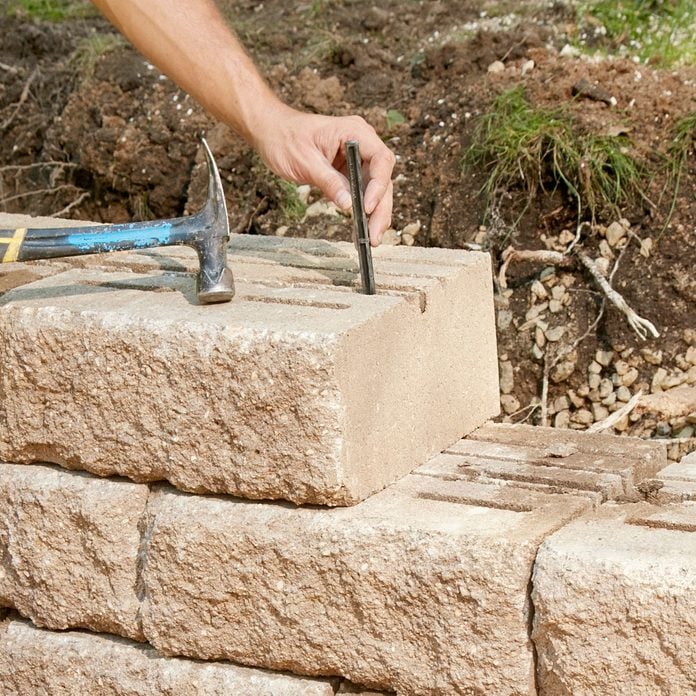Adding a versa lock to a retaining wall block | Construction Pro Tips