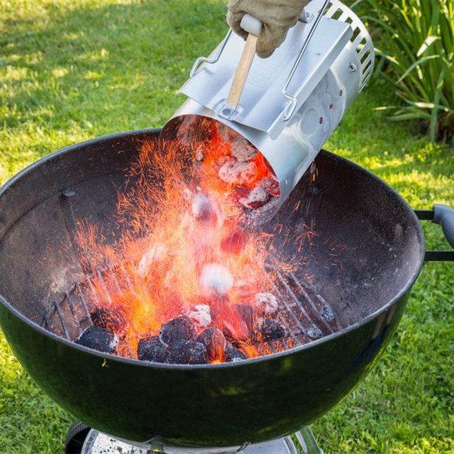 charcoal chimney pouring hot coals in grill