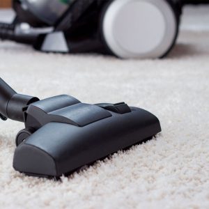 vacuuming white area rug