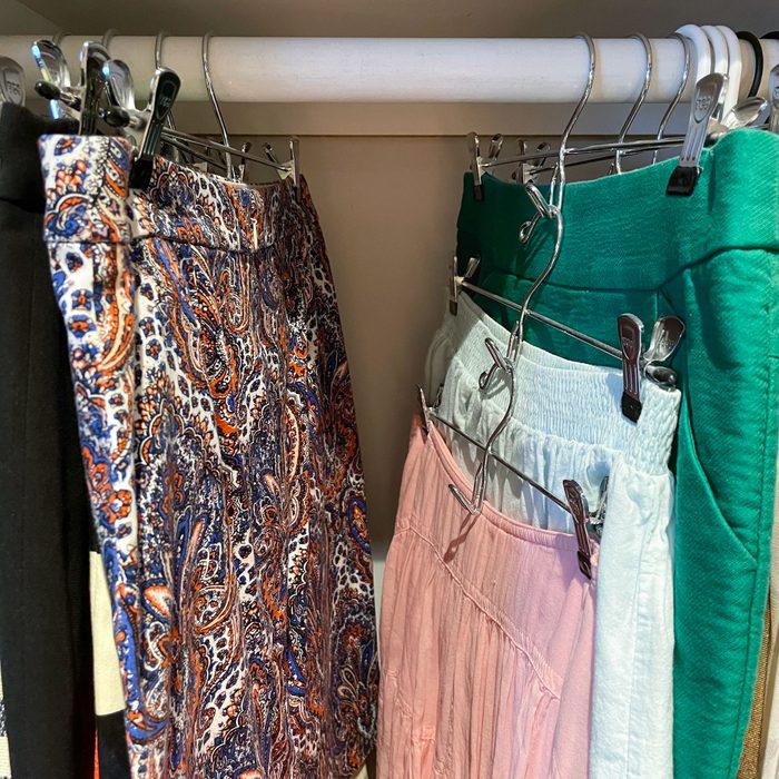 clothes in a dorm closet on tiered hangers to save space