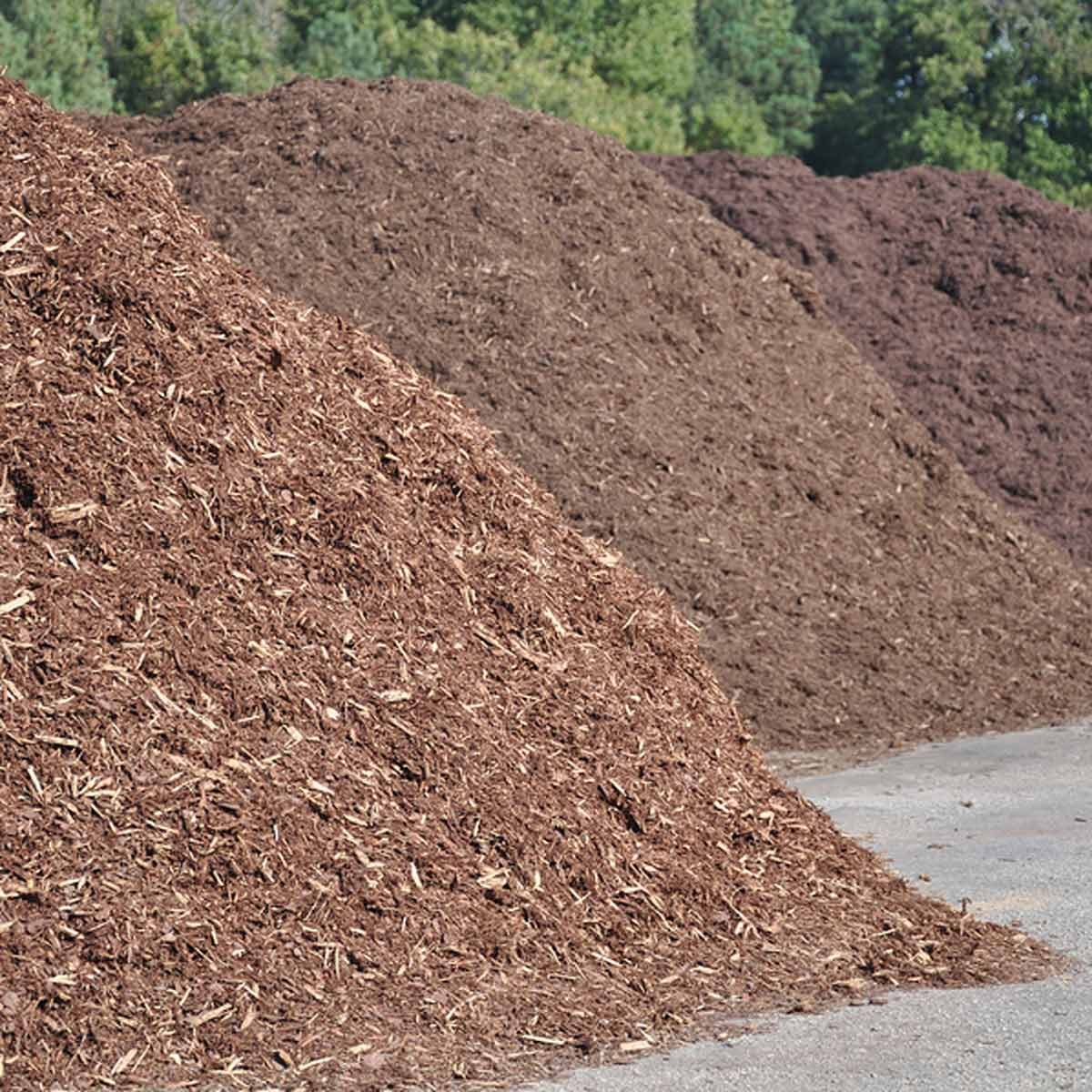 Image of Front-end loader dumping bark mulch into flower bed