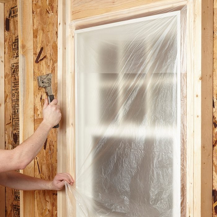 Covering windows with plastic to protect from overspray | Construction Pro Tips