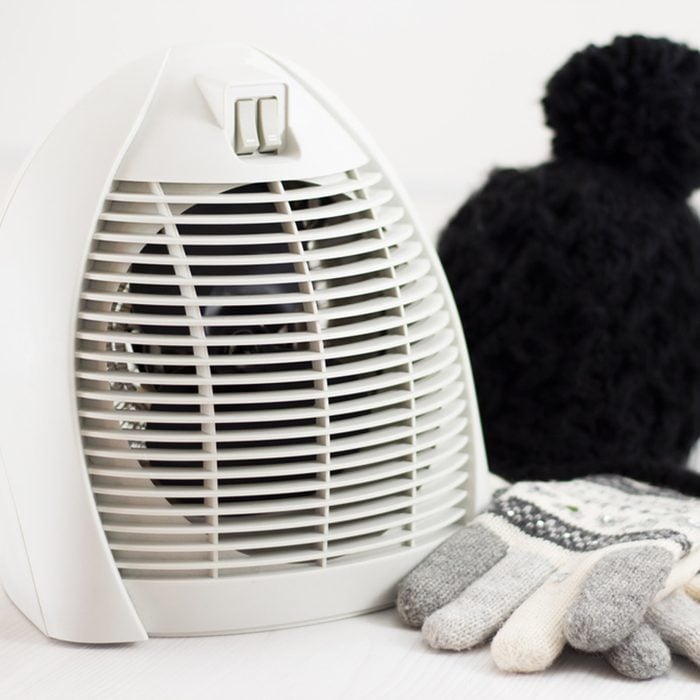 shutterstock_522624481 space heater with mittens and hat