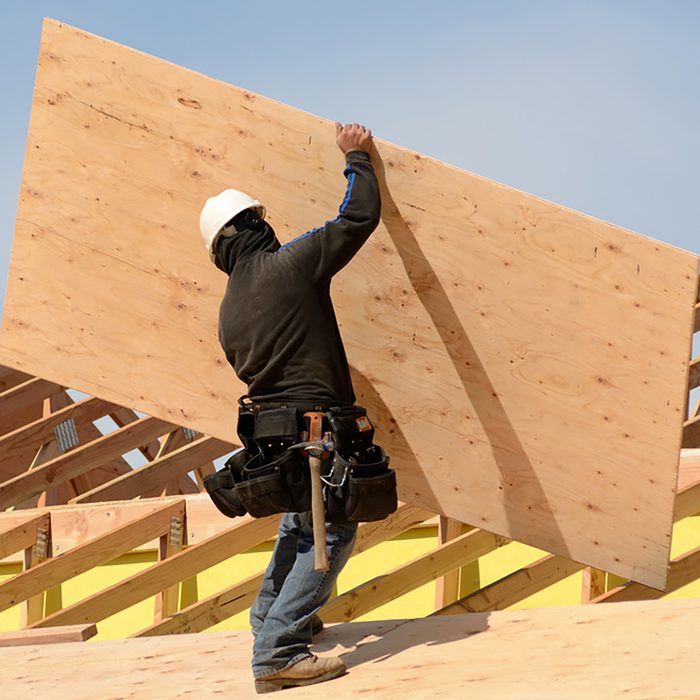 Placing plywood on top of assembled trusses | Construction Pro Tips