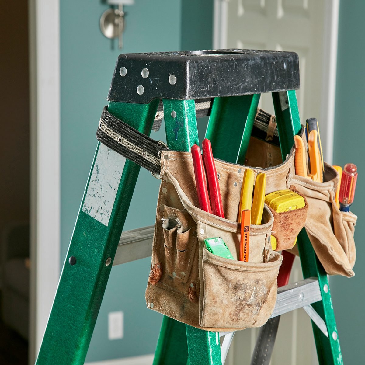 Tool bag draped over a ladder for easy access | Construction Pro Tips