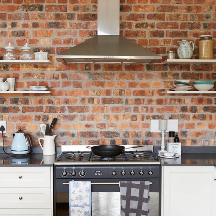 brick wall in kitchen with open shelves