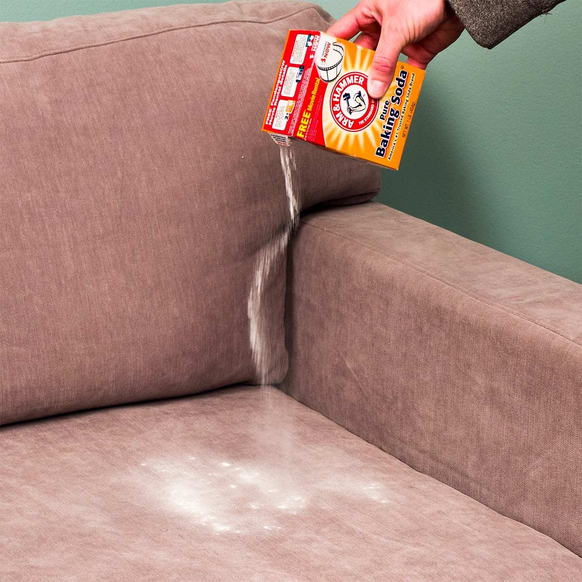 pouring baking soda onto upholstery