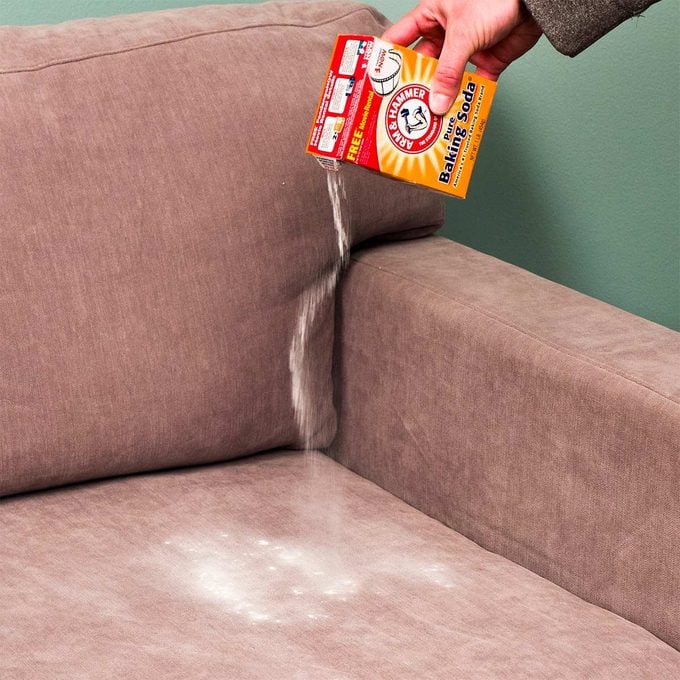 pouring baking soda onto upholstery