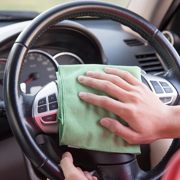 cleaning car interior with a rag steering wheel