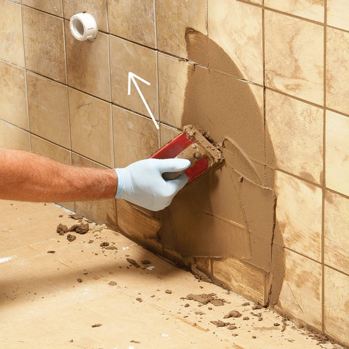 Spreading the grout along a wall of tile | Construction Pro Tips