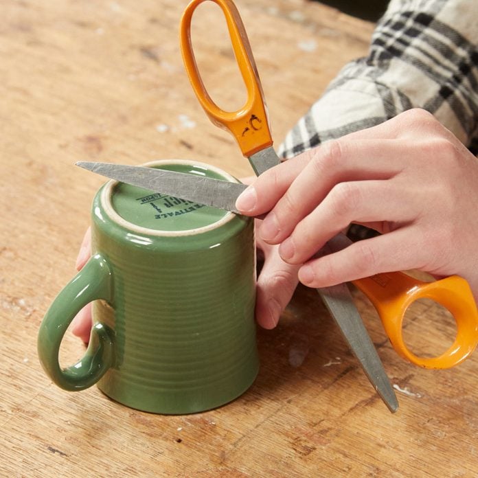 HH sharpening scissor blades on coffee mug