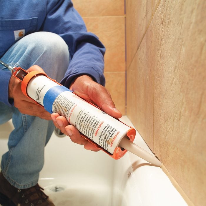 Caulking the tile seam in a bathtub | Construction Pro Tips
