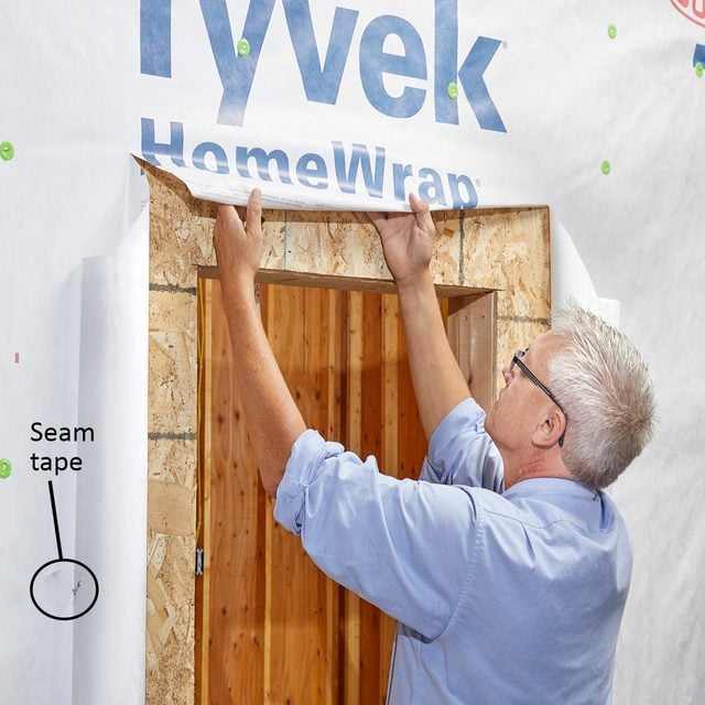 Man rolling Tyvek up and under | Construction Pro Tips