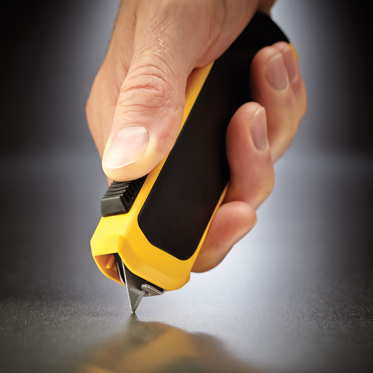 Holding the safety knife from OLFA with thumb on the release | Construction Pro Tips