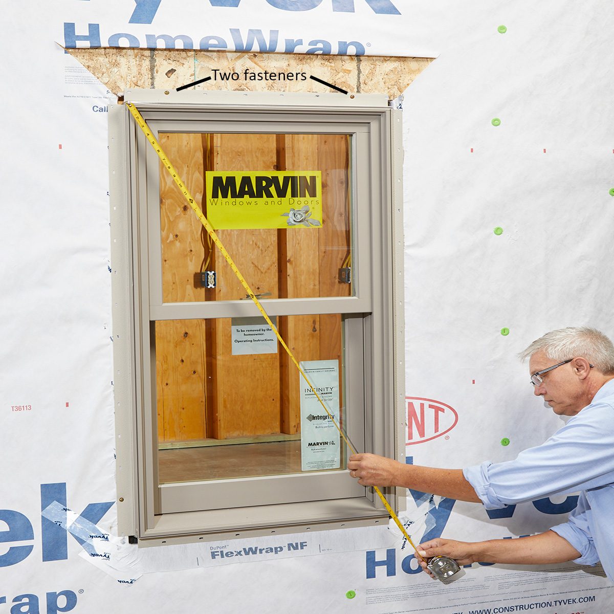 Man squaring and fastening the window with a measuring tape | Construction Pro Tips