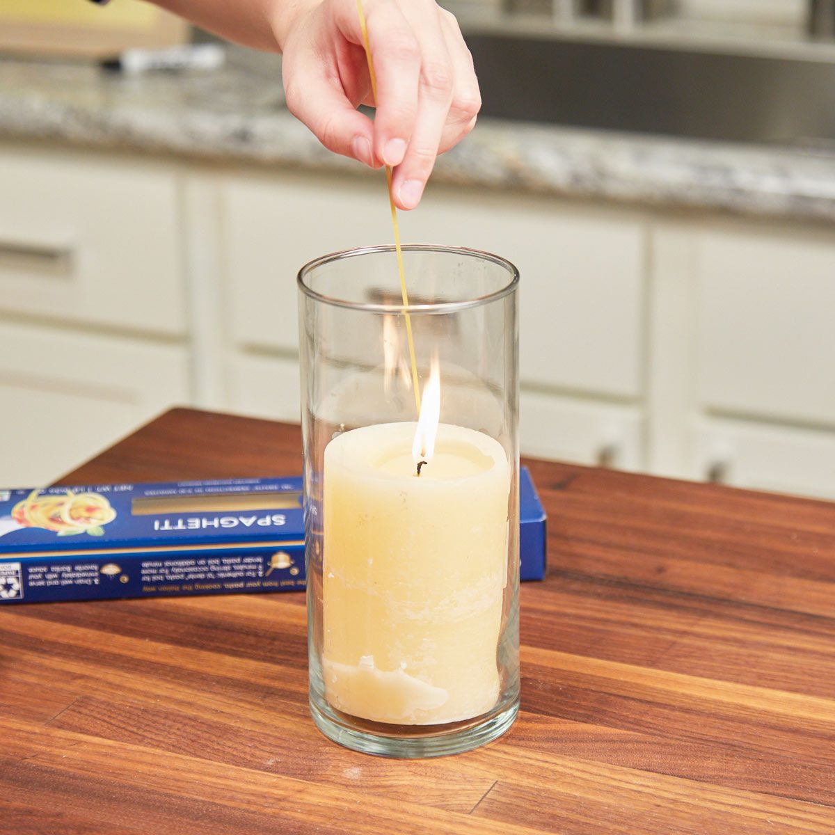 Hand holding a spaghetti noodle as a candle lighter from Family Handyman