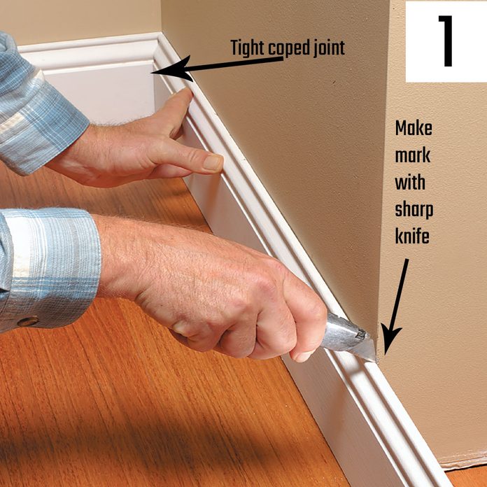 Marking a piece of trim with a utility knife | Construction Pro Tips