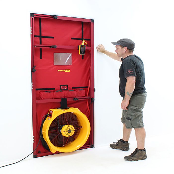 Man standing next to blower door test | Construction Pro Tips