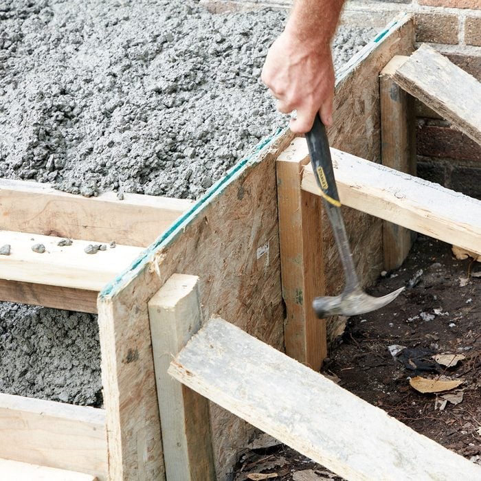 Tapping on the sides of the forms to get concrete to settle | Construction Pro Tips