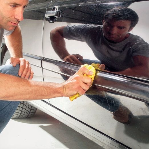 a person applying/mounting the body side molding on car