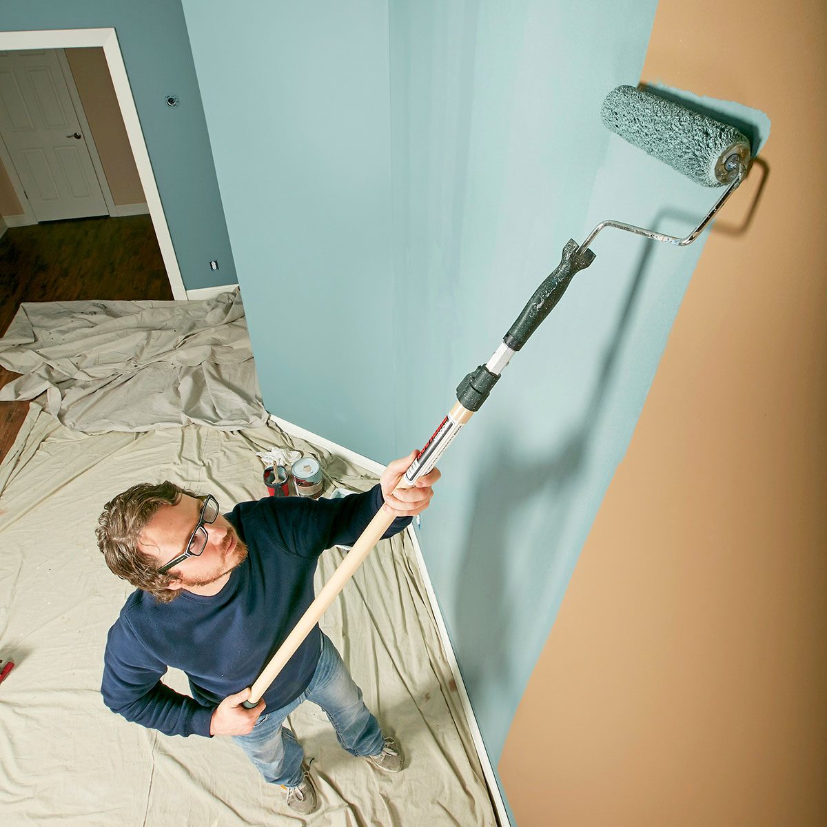 Painter rolling paint onto walls | Construction Pro Tips
