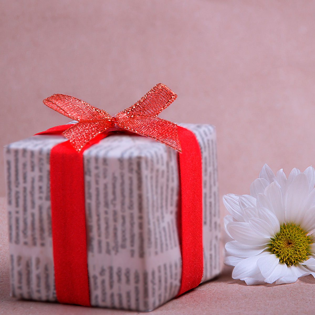 Gift box wrapped in craft paper with a note in the form of a red
