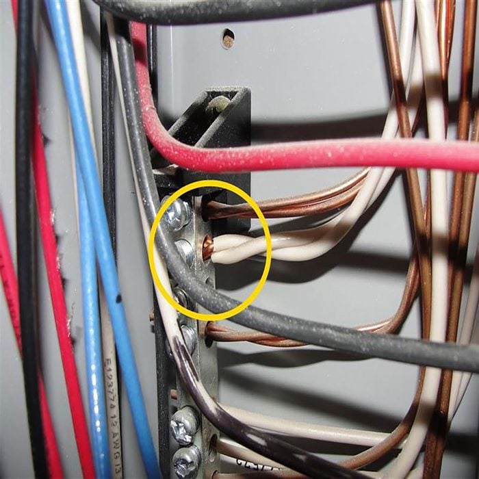 Wires inside of an electrical panel with some circled | Construction Pro Tips
