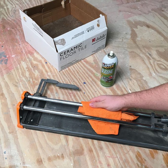Tile cutter being cleaned with silicon | Construction Pro Tips