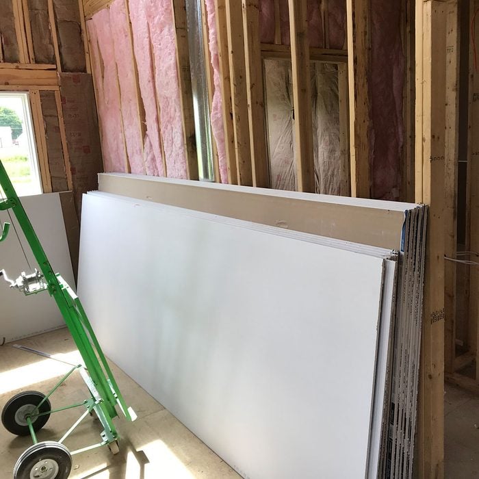 Drywall stacked against bare framing | Construction Pro Tips