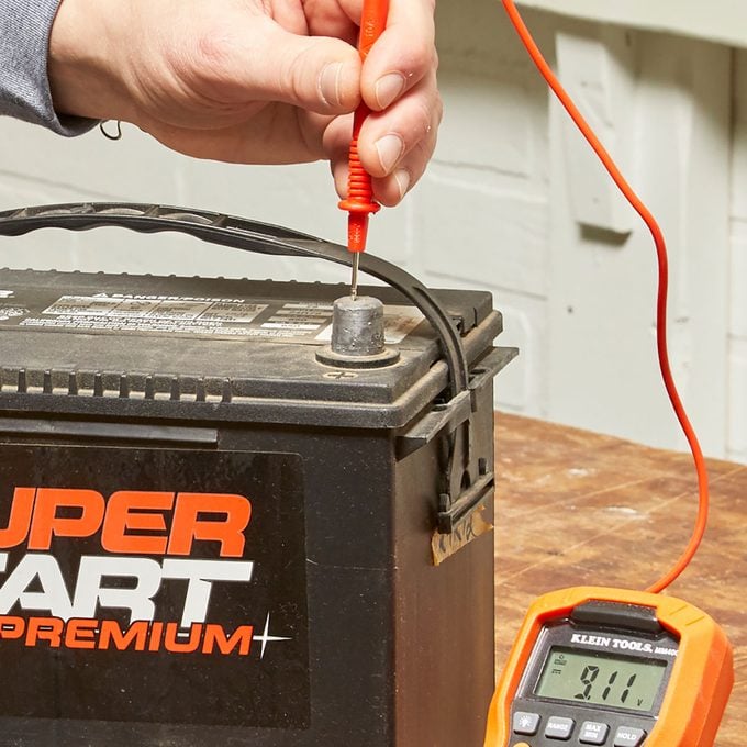 Positive test lead probe on battery | Construction Pro Tips