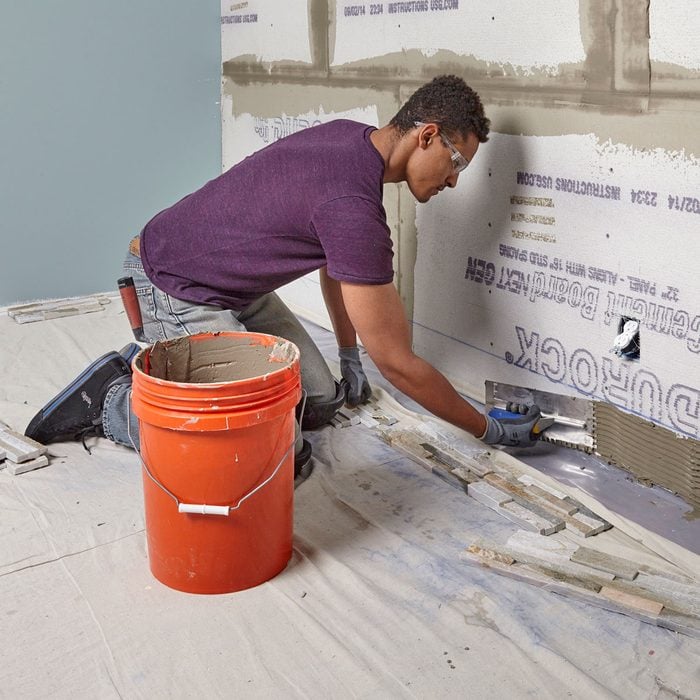 Spread thin-set along the bottom part of the wall | Construction Pro Tips