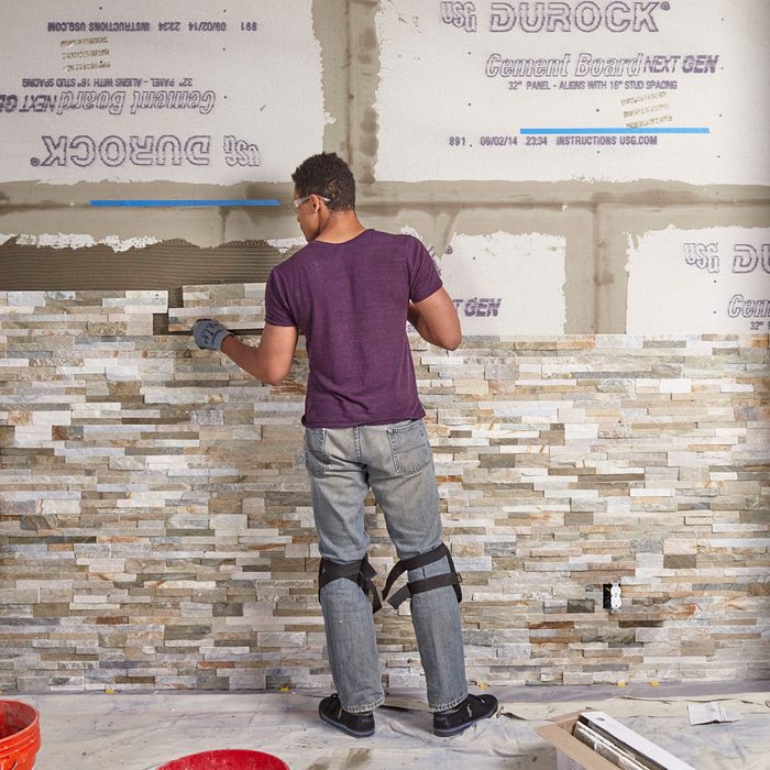 Laying the stone further and further up the wall | Construction Pro Tips