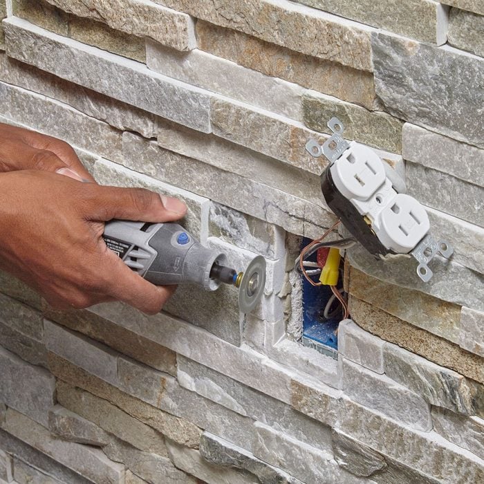 Grinding out the stones around the outlet space | Construction Pro Tips