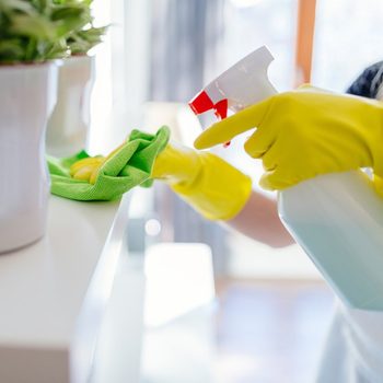 Woman wearing yellow rubber protective gloves and cleaning white shelf.; Shutterstock ID 546648748; Job (TFH, TOH, RD, BNB, CWM, CM): TOH DIY All-Purpose Cleaner