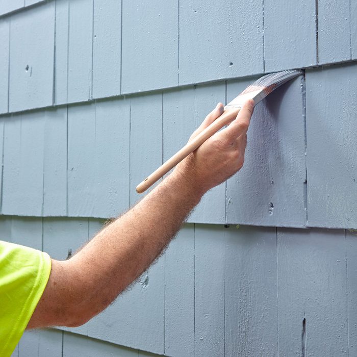 brushing paint on to siding | Construction Pro Tips