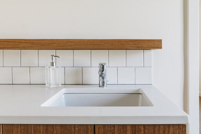 Modern bathroom sink with subway tile backsplash with wood details.