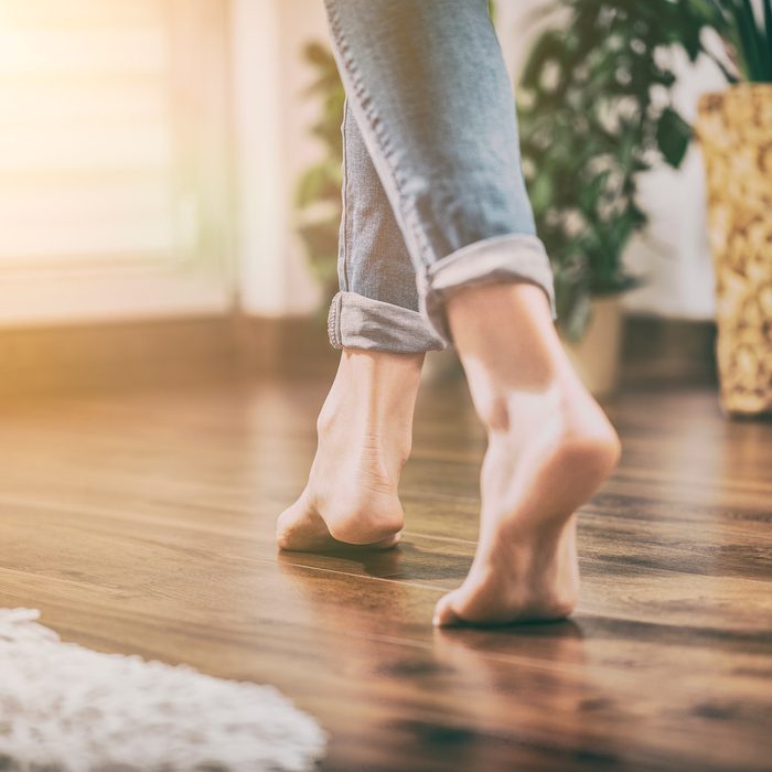 woman walks barefoot on a hardwood Floor