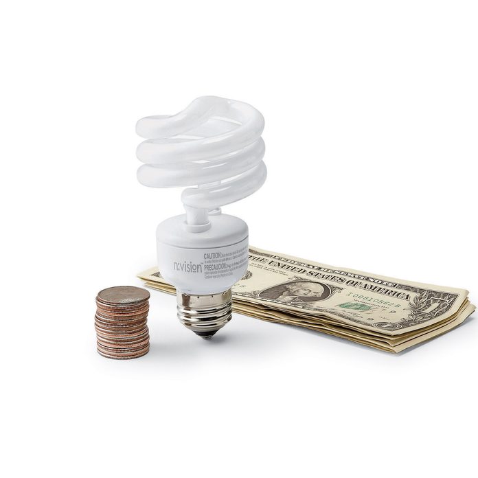 CFL lightbulb between coins and dollar bills