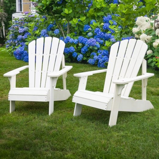 two White Adirondack Chairs in the grass