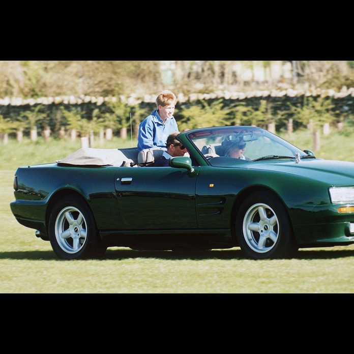 Prince Charles driving Aston Martin convertible car with Tiggy Legge Bourke and Prince Harry riding in the back