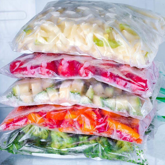 Bags with frozen vegetables in refrigerator, closeup