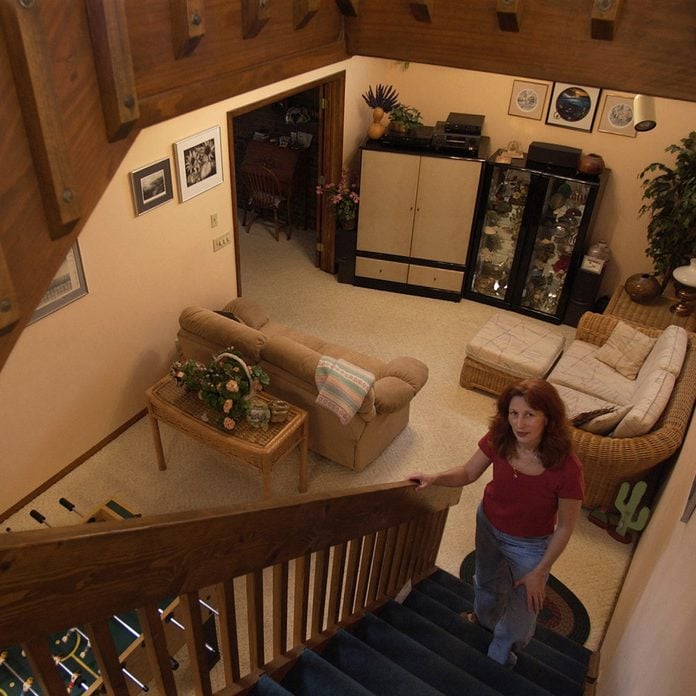 Woman stands in a the stairwell of an underground home