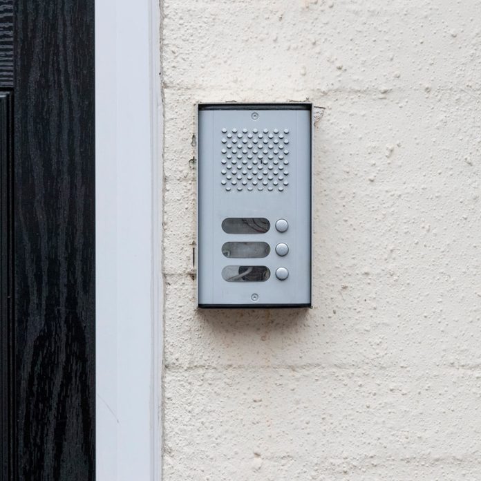 residential-buzzer-intercom-next-to-a-black-door-on-a-white-wall