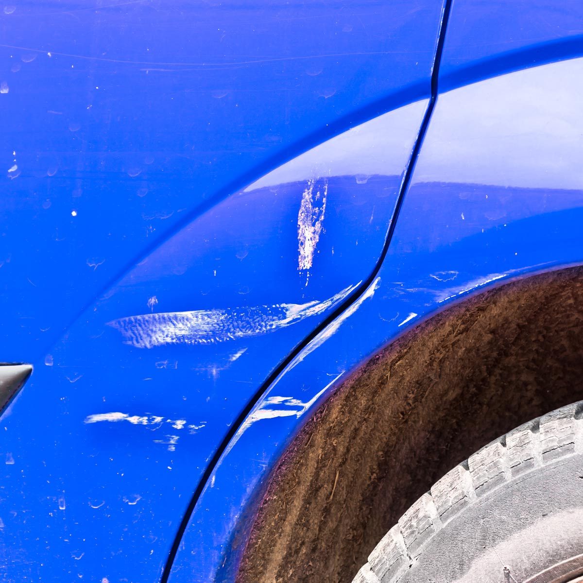 Blue scratched car with damaged paint