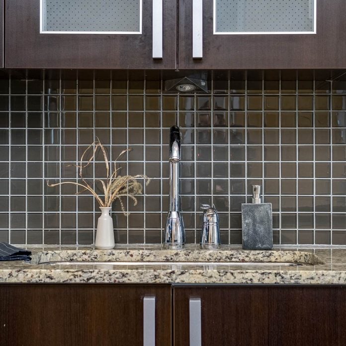 Black-tile-backsplash-in-a-kitchen-with-dark-cabinets