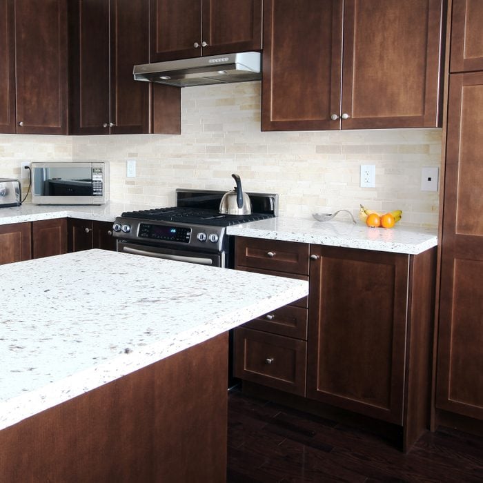 Domestic kitchen with quartz countertops and brown cabinetry