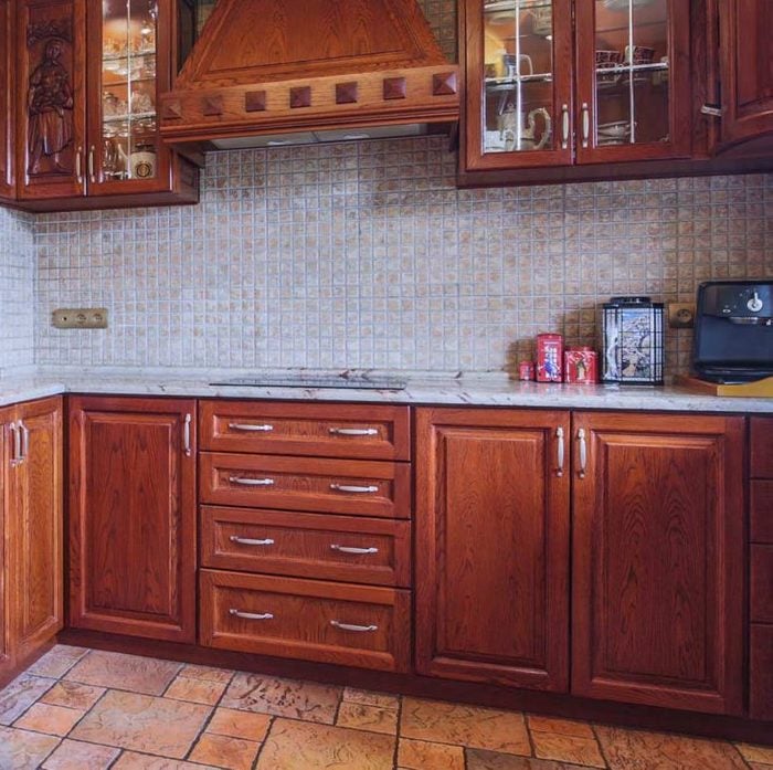 kitchen with cherry wood cabinets and a natural stone mosaic backsplash